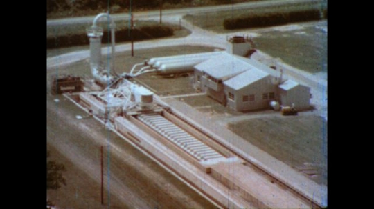 United States: 1980s: close up of research building. Explosion of water makes machine travel. 