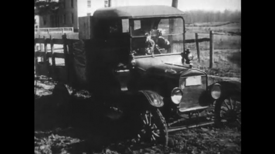 UNITED STATES: 1950s: vehicle gets stuck on muddy road. Workers make roads. 