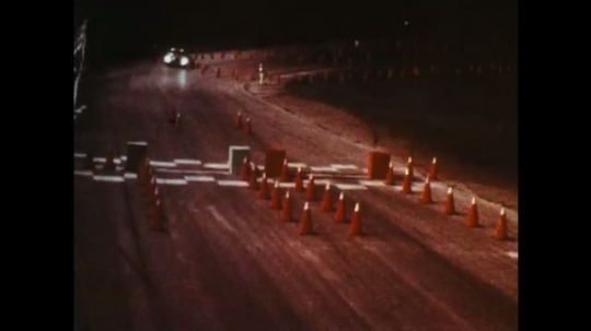 UNITED STATES: 1970s: car drives on track at night. 