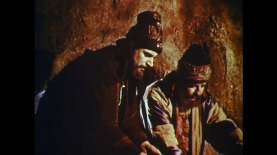 UNITED STATES: 1950s: two men need over their work. Men leave cave