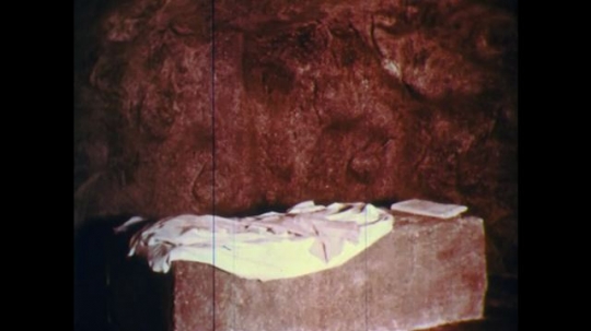 UNITED STATES: 1950s: cloth on stone in empty tomb. Men look inside tomb. Lady arrives at tomb