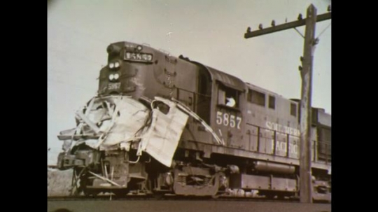 UNITED STATES: 1970s: photos of car hit by train. Men fix crossing lights