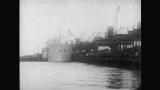 UNITED STATES: 1910s: ship in harbour. Men leave ship with kit. Trains on harbour. 