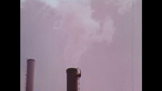 UNITED STATES: 1950s: clouds above factory chimney. Liquid inside furnace