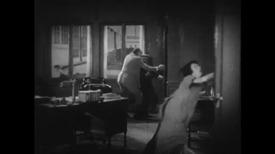 1920s: men and woman hide inside bathroom. lion smashes through transom. paw breaks door and swats at men as woman fights with feather duster. 