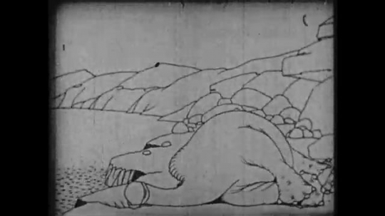 1910s: Animation, dinosaur laying on ground, scratches head with tail. 