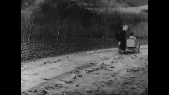 1910s: man with mustache wildly steers motorcycle and restrains woman in sidecar. man with cowboy hat rides horse and fires gun. three men in police uniforms run down dirt road. 