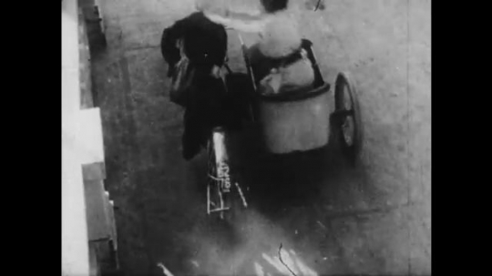 1910s: man with mustache smashes motorcycle through railing and plunges off bridge. Man in cowboy hat throws rope and lassoes woman in midair. man falls in water.