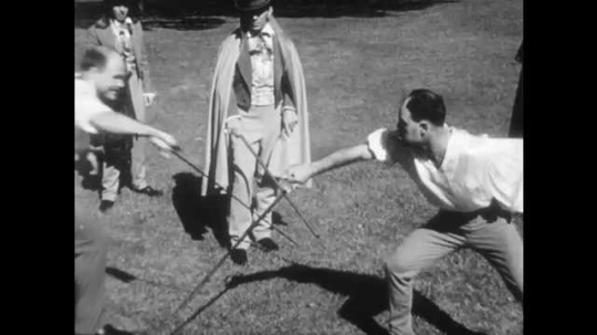 1940s: Men stand outside, watch two men duel. 