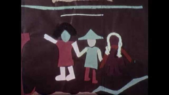 1960s: UNITED STATES: fabric and wool picture. Girl paints picture on ground. Girl paints clown. 