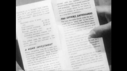 1940s: Hands display The FHA Plan of Home Ownership brochure. Man stands and reads from letter. Man looks and points in front of him. 