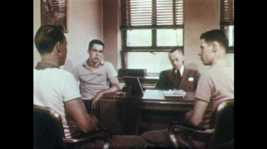 1950s: UNITED STATES: Division of Crime Prevention workers. Police organise baseball match with students. Man assigns paperwork to officers. Boy with baseball bat