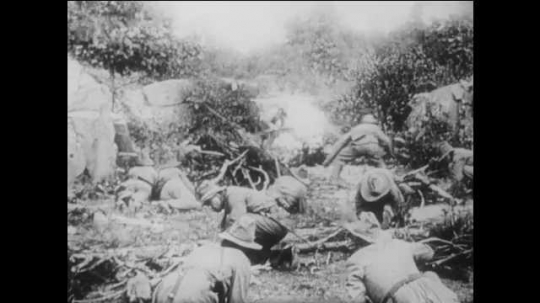 1910s: Confederate troops with hats hide behind rocks and fire rifles. Union soldiers on horseback fire guns in battle. wagon explodes in smoke on field. officer with gun dies in arms of man. 