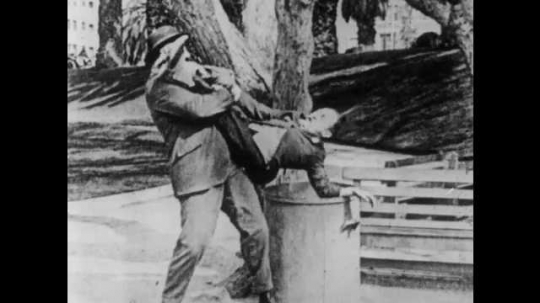 1910s: Boss pulls man from trash can. Man pulls man