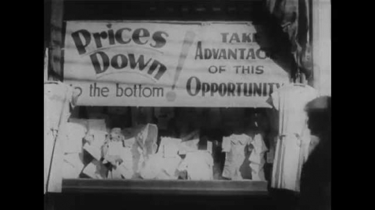 1930s: View of store window, awning lowering. View of storefront. Close up pan of sign on window, hand painting sign.