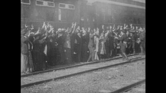 1900s: UNITED STATES: robbers threaten passengers of train. Passenger runs from train. Robber shoots passenger in back